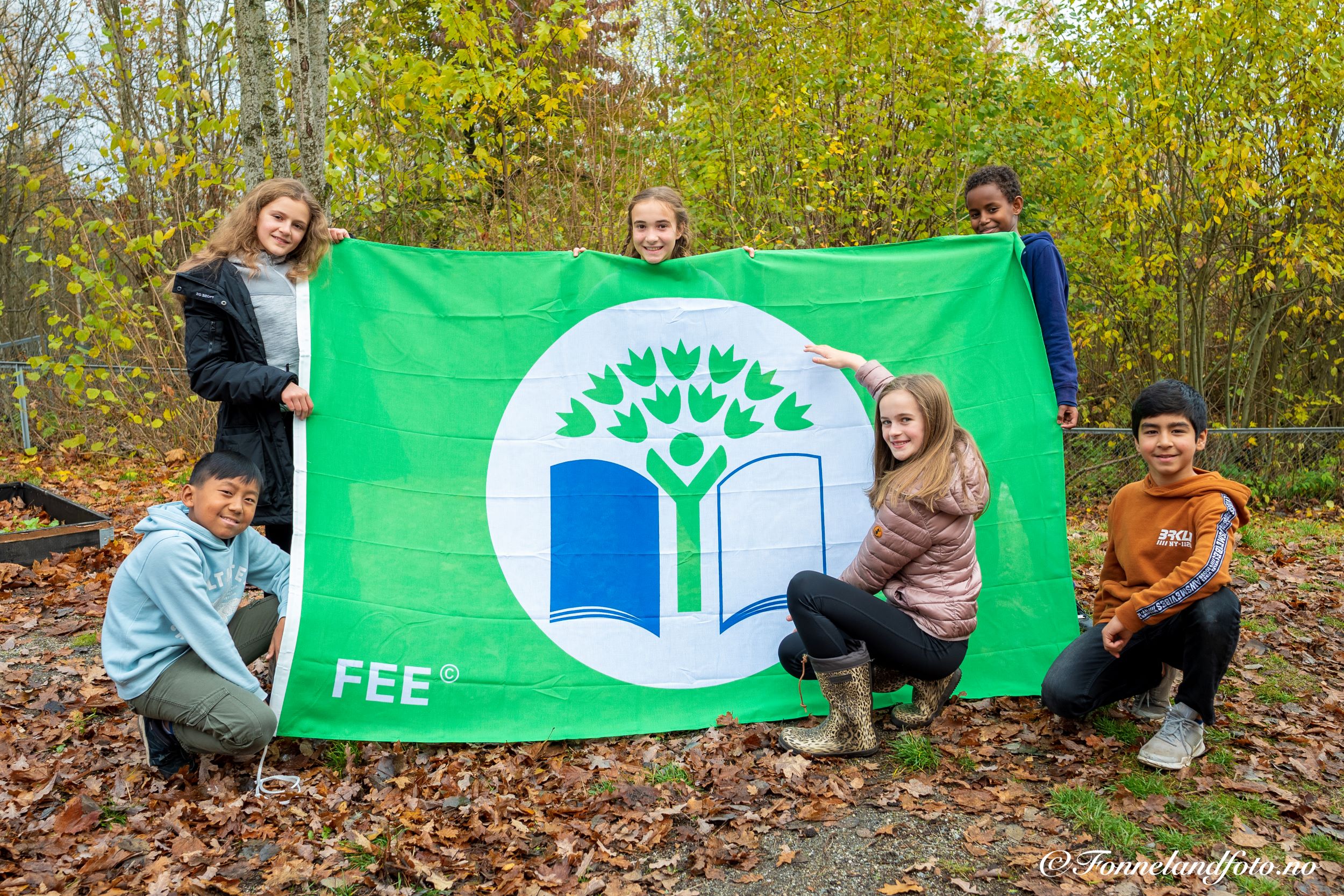 Des élèves de Norvège tiennent un drapeau de la Fondation à l'Education pour l'Environnement.